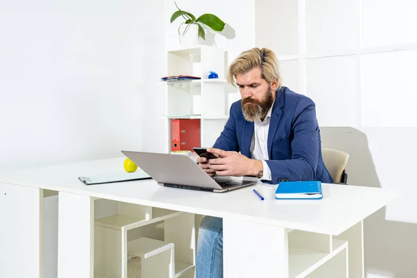 Empresário recebendo boas notícias no telefone ou laptop dentro do escritório. Empresário que governa sua empresa remotamente, como um freelancer. — Fotografia de Stock