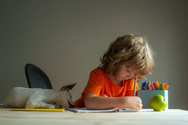 Lindo alumno escuela chico y cachorro estudio en casa. — Foto de Stock