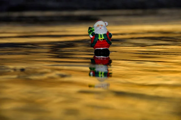 Tomten vid solnedgången. Jul eller nyår dekoration på havet strand bakgrund med kopia utrymme. — Stockfoto