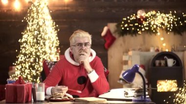 Noel Baba evde, Noel ağacının yanında düşünüyor. Yeni Yıl Tatili.