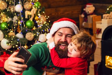 Noel Baba ve yaşlı sakallı Noel Baba akıllı telefon kullanıyor. Kış Noel heyecanı. İnternet, kablosuz ve sosyal medya kavramı.