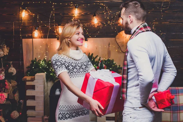 Glad kvinna och man ger julklappar till varandra. Ett underbart lyckligt par. Julpar förälskade. Lycka till. — Stockfoto