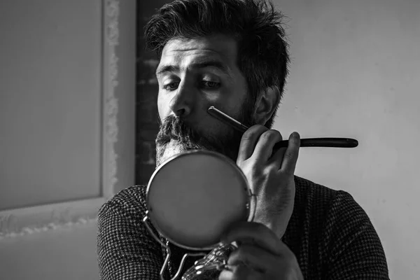 Um brutamontes na Barbearia moderna. Guarnições. Bons momentos na barbearia. Barbeiro fazendo corte de cabelo de homem barbudo atraente na barbearia. Homem barbudo ou hipster. Ideias sobre Barbearia e Barbeiro salão. — Fotografia de Stock