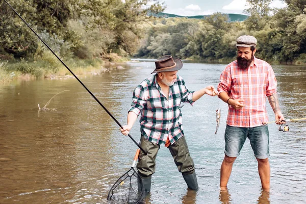 Fliegenangler auf dem Fluss. Angler. Familie und Generation - Sommerurlaub und Menschen-Konzept. Fischer mit Angelrute auf dem Fluss. — Stockfoto