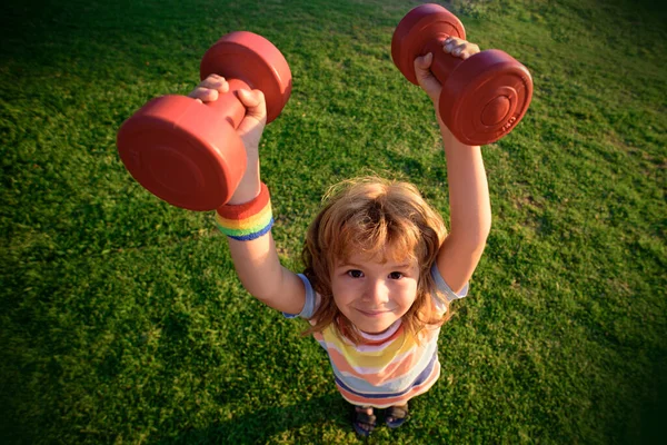 Divertimento fitness, allenamento per bambini all'aperto. Bambino divertente con i manubri. — Foto Stock
