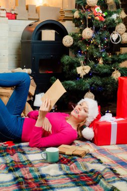 Yeni partiniz kutlu olsun. Noel hediyesi. Güzel Noel Baba kadını. Şehvetli genç kız. Kırmızı Noel Baba şapkalı kadın hediyesini tutuyor. Noel modası. Kadın Noel.