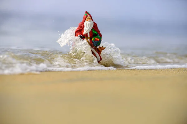 Santa Claus toy. Holiday and vacation concept. Christmas or New Year decoration on sea beach background with copy space. — Stock Photo, Image