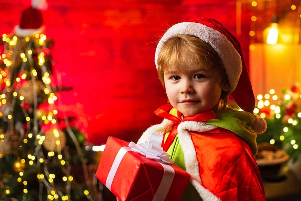 Kid enjoy winter holiday at home. Home filled with joy and love. Merry christmas and happy new year. Best wishes. Family holiday. Christmas gift. Cute little child boy play near christmas tree — Stock Photo, Image