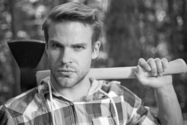 Oduncu adam omzunda balta taşıyor. Yaz ormanında baltalı oduncu. Oduncu baltayı tutuyor..