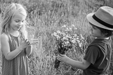 Macera ve tatiller çocuk konsepti. Mutlu çocuklar yazın doğada çayırda sarılır. Aşık küçük melekler. Sevgililer günün kutlu olsun. Çocuk bakımı. Aşk konsepti. İlk aşk.