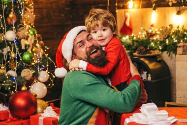 Neşeli şirin çocuk Noel hediyesini açıyor. Hediye duyguları. Noel hediyesi kutusu olan mutlu bir baba ve oğul. Yeni yıl konsepti Noel 'den önceki sabah.