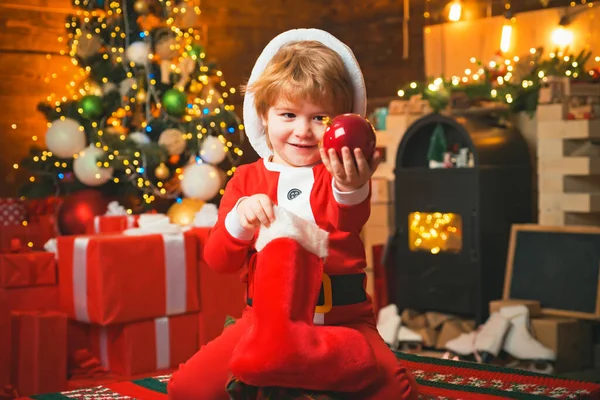 Szczęśliwe dziecko w stroju Mikołaja z kulą ozdobną. Zimowa dostawa dla dzieci. Dobrze się bawię. Boże Narodzenie cud i uczucia nowego roku. — Zdjęcie stockowe