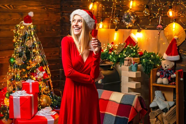 Señora alegre en fiesta de Navidad corporativa vestido. Feliz fiesta de año nuevo. Celebra la Navidad. Mujer elegante vestido rojo niña celebrar la Navidad. Chica cerca de árbol de Navidad decoración de invierno interior —  Fotos de Stock