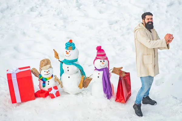 Der Weihnachtsmann wünscht frohe Weihnachten. Modemann mit Weihnachtsgeschenkschachtel. Lustiger Weihnachtsmann posiert bei Winterwetter mit roter Geschenkbox. — Stockfoto