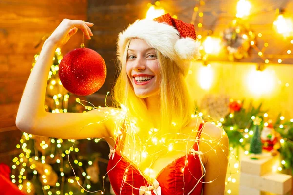 Seksi erotik kız yeni yılı ve mutlu noelleri kutluyor. Seksi iç çamaşırlı noel kutlaması. Bütün bir yıl boyunca huzur ve neşe. Kız Noel Baba şapkası Noel ağacının yanında. Noel için kırmızı iç çamaşırı. — Stok fotoğraf