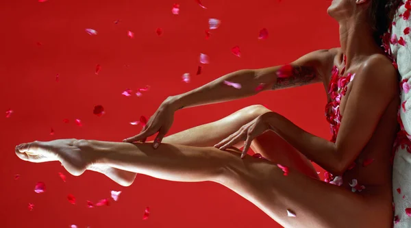 Orgasm. Sensual naked woman enjoing love and orgasm. Sexual smooth legs in bed rose petals. Beauty day and body care concept. Sexy and care copy space. Female comfort and orgasm. Red is love. — Stock Photo, Image