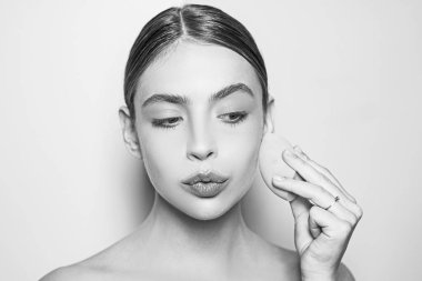 Mükemmel ten rengi. Kapatıcı ve kozmetik fosforlu kalem kullan. Kızın elinde kozmetik aplikatör var. Kadın yüzüne krem sürüyor. Cilt kremi kavramı. Kadın için yüz bakımı. Taze sağlıklı deri konsepti