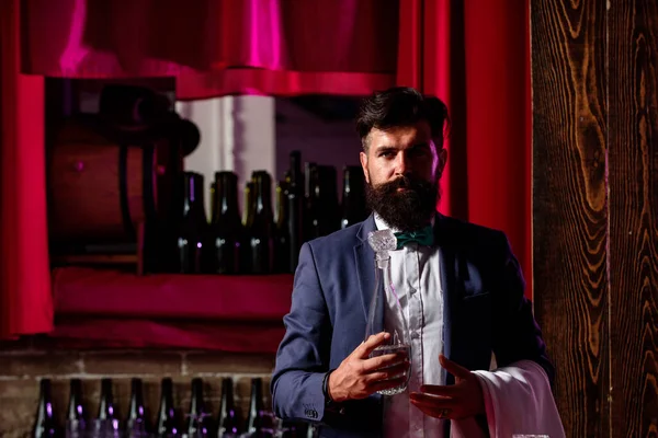 Barman z brodą stojący na tle baru. Barman w barze robi napój alkoholowy. Profesjonalny barman. — Zdjęcie stockowe