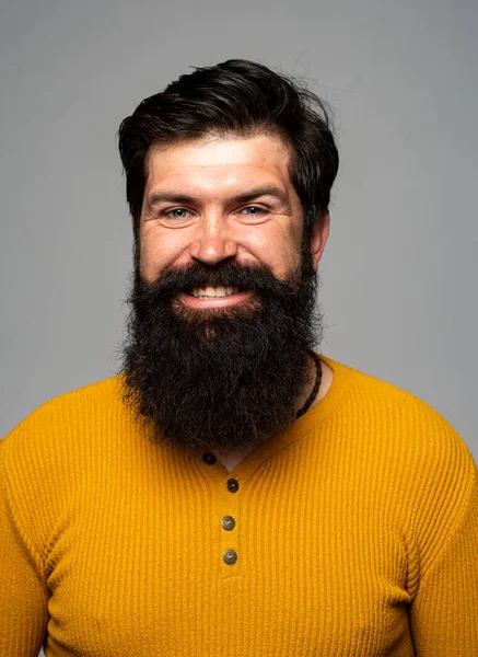 Счастливый мужчина улыбается. Парикмахер с длинной бородой и усами в парикмахерской. Красивый улыбающийся молодой парень. Позитивные выражения лица и эмоции человека. — стоковое фото