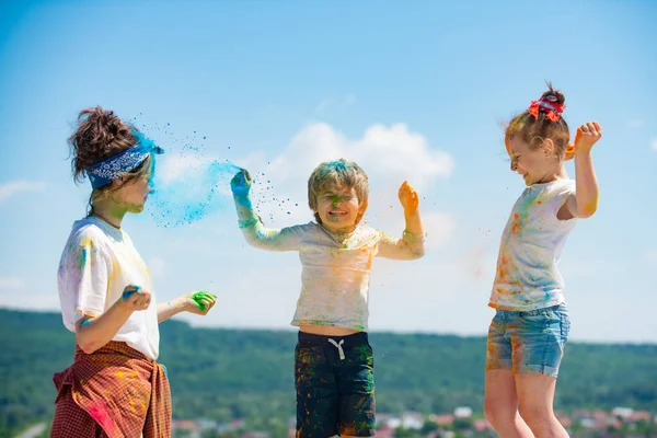 Helle und fröhliche Kinder, die mit farbigem Puder spielen. — Stockfoto