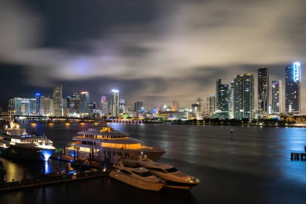 Iate ou barco ao lado do centro de Miami. Bela cidade colorida de Miami Florida horizonte e baía com nuvens noturnas. — Fotografia de Stock