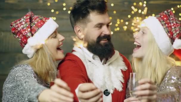 Retrato de amigos sonrientes de grupo sobre fondo navideño. Gente amigable en Santa Claus brindando con champán por árbol de Navidad. — Vídeos de Stock