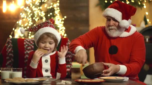O avô de Santa com o pequeno rapaz prepara o Natal e o Ano Novo, assando biscoitos de Natal na cozinha decorada. Humor de férias — Vídeo de Stock