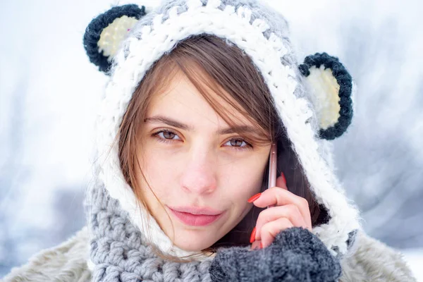 Retrato de uma jovem mulher na neve. Mulher de inverno usando telefone celular ou smartphone. Retrato de inverno menina feliz com smartphone. — Fotografia de Stock