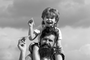 Nesil. Baba oğlunu parka geri götürüyor. Baba ve oğul birlikte kağıt uçak yapıyorlar. Mutlu bir babanın portresi. Oğlunu sırtında taşıyor ve yukarı bakıyor..