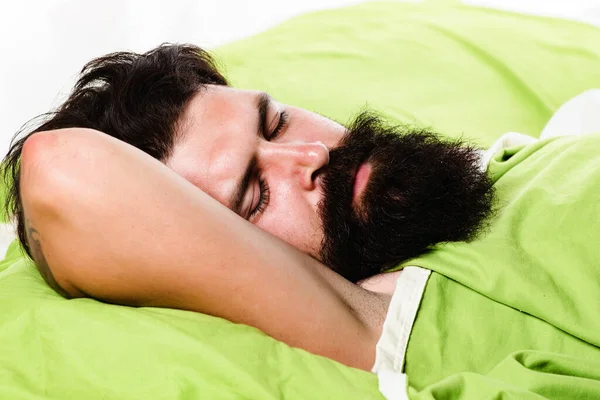 Violations of sleep and wakefulness. Young man sleeping on soft pillows in bed at home. Man bearded hipster having problems with sleep. — Stock Photo, Image