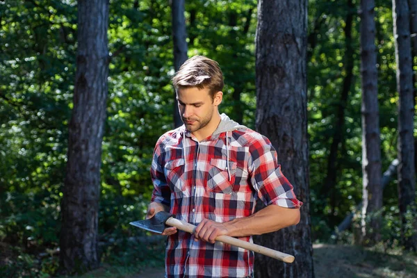 Houthakker met bijl op bosachtergrond. Ontbossing is een belangrijke oorzaak van landdegradatie en destabilisatie van natuurlijke ecosystemen. — Stockfoto