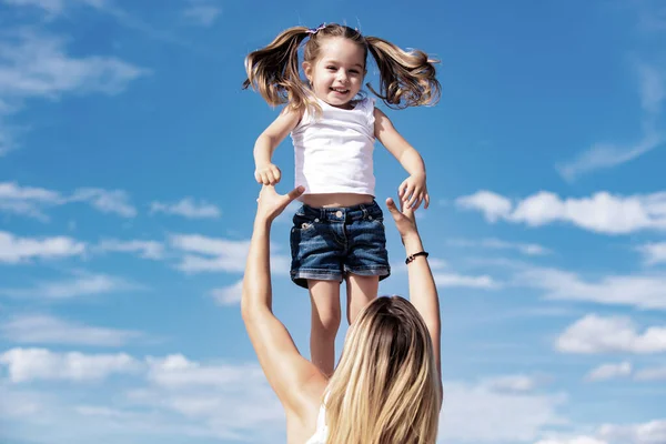 Захоплена дівчинка. Щаслива любляча сім'я - мати і дочка. Мати і дочка на фоні блакитного неба. Щасливий день матері . — стокове фото