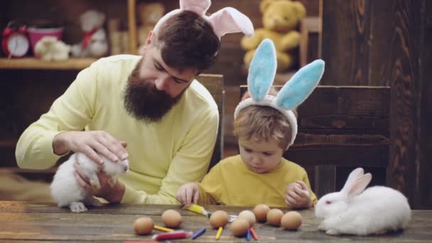 Családi játék húsvéti nyuszival. Apa és fia húsvéti nyuszifülekkel.