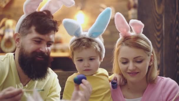 Familjen målade påskägg. Far, mor och son bär kaninöron hemma. Lyckliga familjeansikten. — Stockvideo
