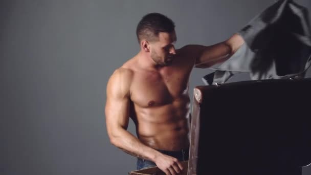Schöner kaukasischer Mann mittleren Alters mit nacktem Oberkörper, der seinen Reisekoffer packt. Sexy Kerl packt Reisekoffer. — Stockvideo