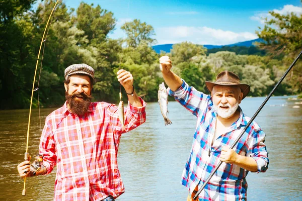 Vissen werd een populaire recreatieve activiteit. Vissen. Generaties leeftijden: grootvader en vader. Grootvader en jongen samen vissen. — Stockfoto