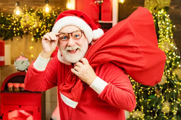 Noel Baba mutlu Noeller diliyor. Noel Baba Noel çantasıyla evde. Komik Noel Baba. Olgun bir Noel Baba portresi. Mutlu Noeller ve mutlu yıllar.. — Stok fotoğraf