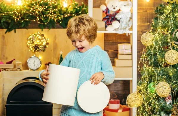 Szczęśliwy chłopiec dziecko z prezent lub pudełko w środku. Happy cute dziecko w Santa kapelusz z prezentem mają Boże Narodzenie. Świąteczne dzieci. Boże Narodzenie dziecko trzyma czerwone pudełko prezent. — Zdjęcie stockowe