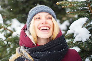 Kış tatilinin tadını çıkarıyorum. Sarışın kadın kışın gülümseyen doğa geçmişi. Noel ve yeni yıl. Model yumuşak kız sıcak şapka eşarbı. Kış moda konsepti. Mutlu kız kış günü kar oynuyor.