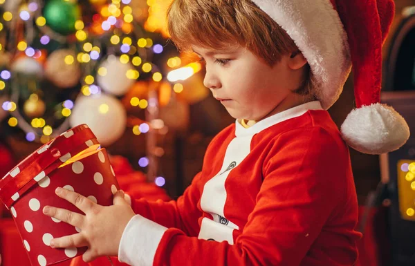 プレゼントボックス。サンタ・ボーイは家でクリスマスを祝う。自分の子供だ。家だ。子供の頃。休日だ。屋内だ。ショッピング販売。奇跡です。子供陽気な顔持ってギフトでクリスマスボックス. — ストック写真