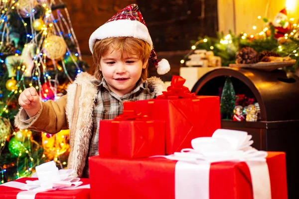 Zimowe świąteczne emocje dziecka. Dzieci cieszą się świętami. Szczęśliwy chłopiec dziecko z prezent lub pudełko w środku. Zimowy dzieciak. Cute little dziecko w pobliżu choinki. — Zdjęcie stockowe