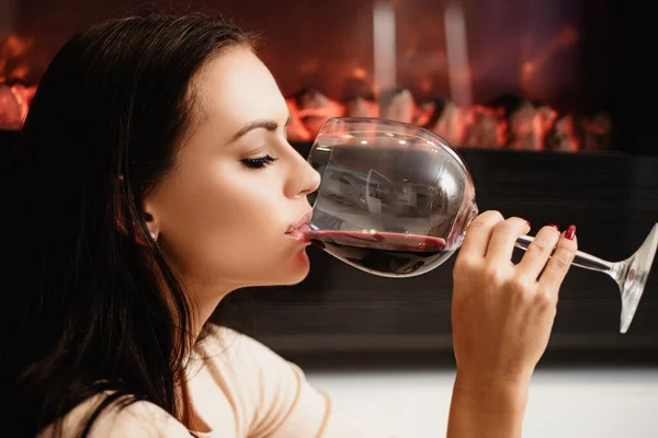 Розкішне вино. Насолоджуйтесь благородним смаком французького вина. Ресторан і виноробня. Чудова леді п'є гастрономічне вино. Дівчина приваблива жінка макіяж обличчя п'є вино вино вино скляний фон камінний фон — стокове фото