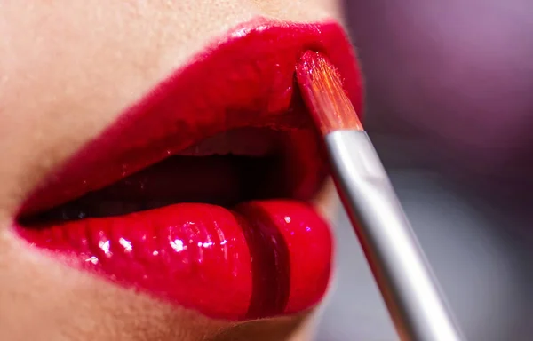 Feche lábios sexy com batom. Mulher bonita pintando batom vermelho nos lábios. Jovem mulher aplicando sua maquiagem. Tinturas seus lábios batom cor vermelha. — Fotografia de Stock
