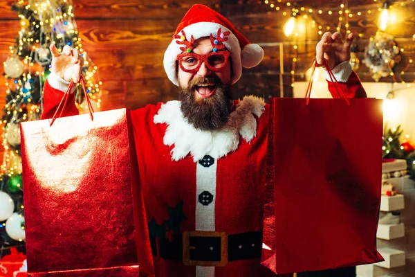 Рождественская подготовка - человек, празднующий Новый год. Стиль Санта-хипстер с длинной бородой позирует на рождественском деревянном фоне. Веселый, смешной хипстер Санта. — стоковое фото