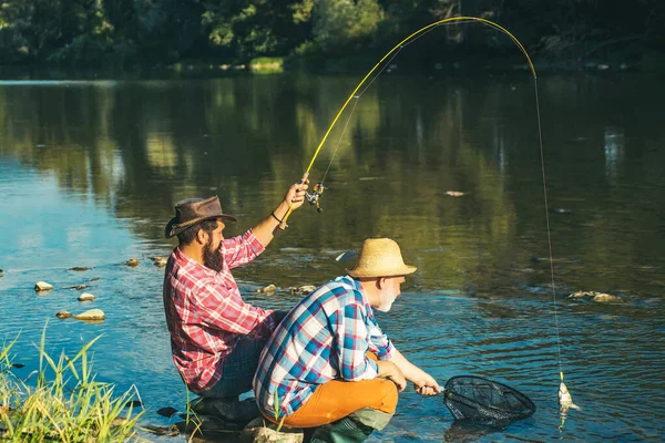 Rybář chytí rybu. Muškaření je nejznámější jako metoda pro lov pstruhů a lososa. — Stock fotografie