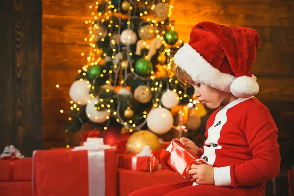 家族の休日。男の子かわいい子供陽気な気分はクリスマスツリーの近くで再生します。メリーと明るいクリスマス。素敵な赤ちゃんはクリスマスをお楽しみください。子供の頃の記憶。サンタ少年の子供お祝いクリスマスに家 — ストック写真