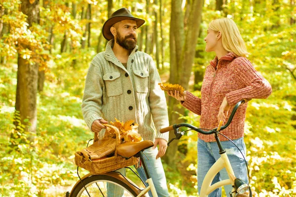 Autumn date hike in forest. Couple in love ride bicycle together in forest park. Romantic date with bicycle. Bearded man and woman relaxing in autumn forest. Romantic couple on date. Date and love