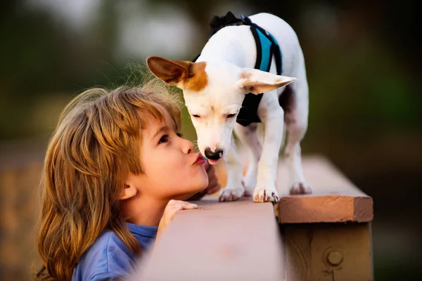 Portrait enfant garçon baiser chiot chien. Ami animal de compagnie. Photo drôle d'enfant heureux étreignant beau chien chiot. — Photo
