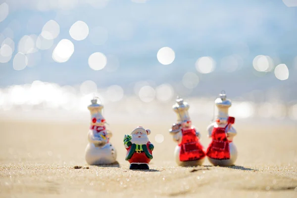 Snowman in santa hat on the sea beach. New Year and Christmas holidays. Santa Claus gifting gift. Festive header design for your website. — Stock Photo, Image