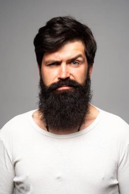 Kendine güvenen ciddi bir adamın portresi sakalı ve bıyığı var, ciddi ve izole görünüyor. Stüdyodaki hippi adam modelleri. İş adamı düşüncesi. Sakallı, şık saçlı, yakışıklı bir erkek..